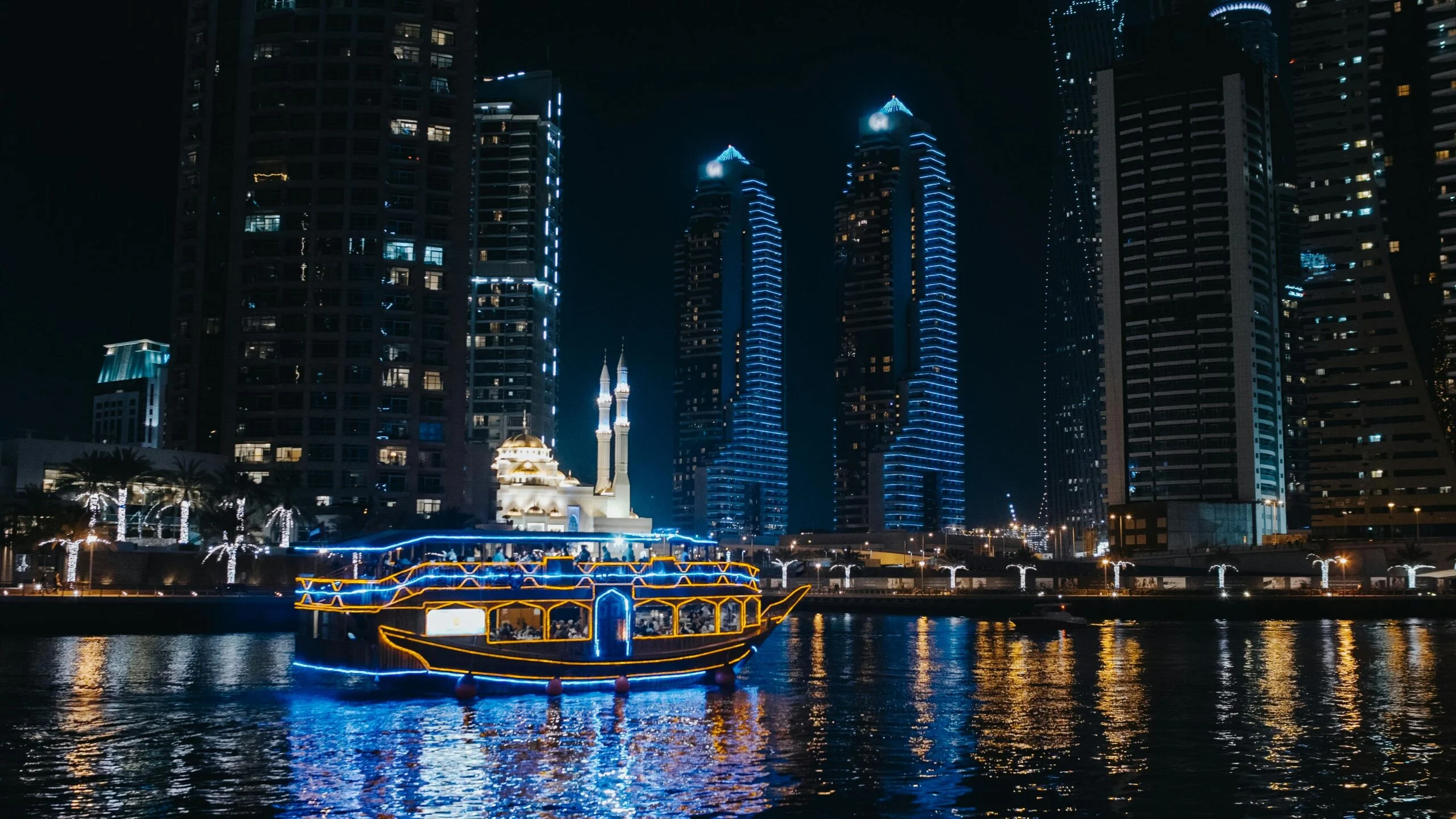 A Boat Sailing On River Near City Buildings During Night Scaled 1
